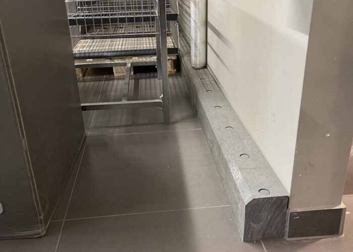 Stabiler grauer Bodenrammschutz zum Schutz von einer Wand in einem Anlieferungsbereich.