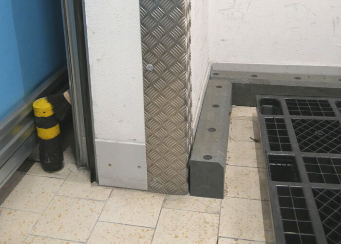 Stabile graue Fußbodenleisten aus Kunststoff zum Schutz einer Wand vor Beschädigung durch anfahren mit einem Hubwagen.